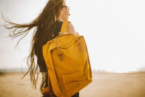 A woman carrying a yellow backpack